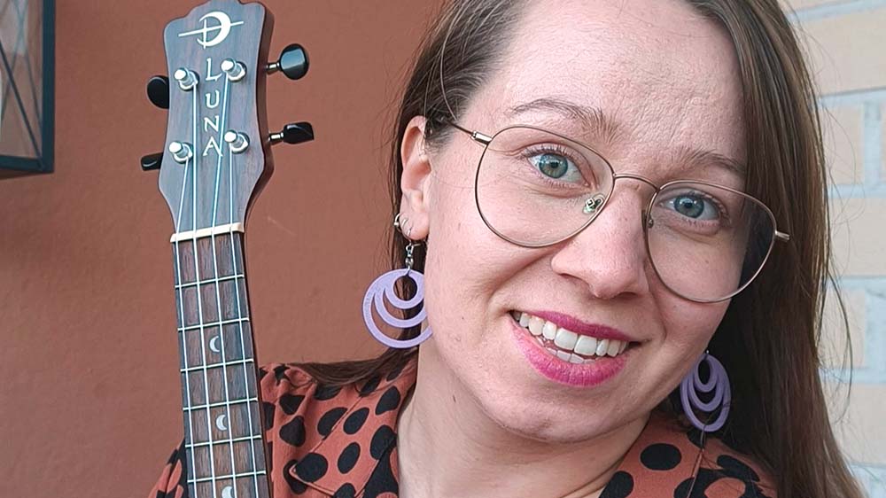 Artisti Sini-Mia hymyilee ukulelen kanssa.